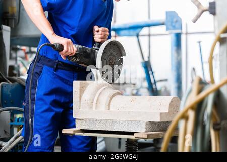 Female sculptor cutting stone with 