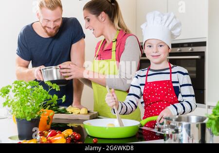Happy family cooking together in kitchen Stock Photo