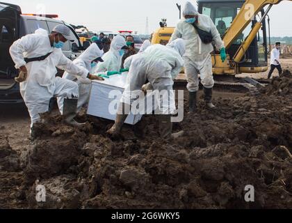 East Jakarta, Indonesia. 08th July, 2021. (Editors note image depicts death) Undertakers wearing Personal Protective Equipment suits (PPE) lower the coffin of a covid-19 victim for burial at Rorotan public cemetery. Indonesia on Thursday reported a new daily record of 38,391 coronavirus infections, plus 852 new fatalities, its second-highest daily death toll, official data showed. Indonesia has recorded 63,760 coronavirus deaths so far and more than 2400000 million cases in total. Credit: SOPA Images Limited/Alamy Live News Stock Photo