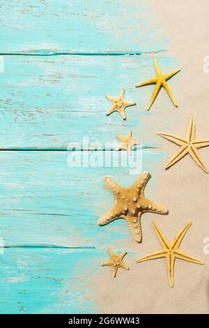 Starfishes on a light blue wooden background with sand and copy space Stock Photo