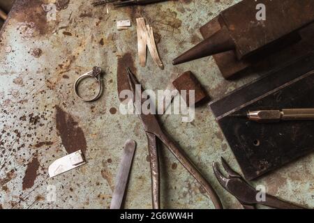 Vintage jeweler's desk with various tools and gold ring, top view Stock Photo