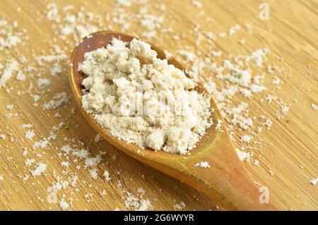 Spice type used to give flavor in powder mahleb or mahaleb pastries, in wooden spoon, on bamboo cutting board Stock Photo