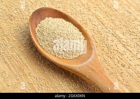 Active granulated yeast, instant dry sourdough, on a bamboo cutting board in wooden spoon Stock Photo