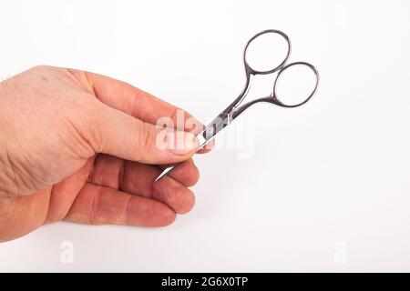 Very sharp retro professional small tailor scissors and hand, isolated on white background Stock Photo