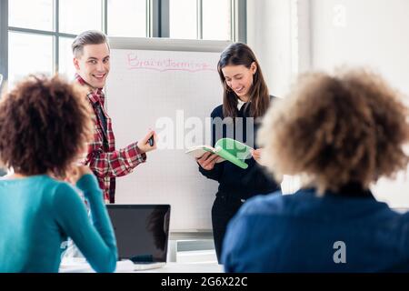 Involved students sharing ideas and opinions while brainstorming during an interactive class in the classroom of a modern college or university Stock Photo