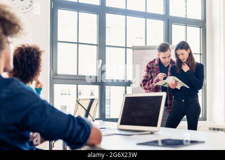 Involved students sharing ideas and opinions while brainstorming during an interactive class in the classroom of a modern college or university Stock Photo