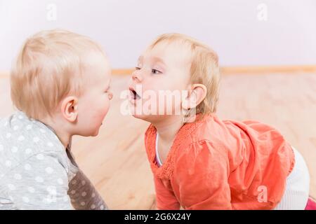 Two toddlers in kindergarten playing with each other Stock Photo