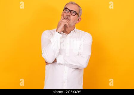 isolated senior adult man with glasses thinking Stock Photo