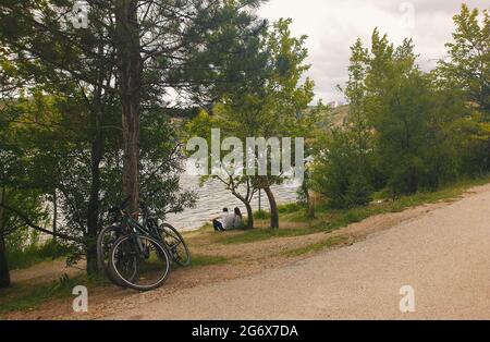 Ankara; Turkey-July 04; 2021: Couple sitting by the lakeside and viewing beautiful view and in Lake Eymir in Ankara. People getting used to new normal. Stock Photo