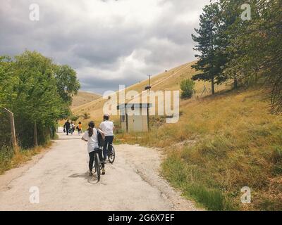 Ankara; Turkey-July 04; 2021: Couple riding cycle while other people walking on the road in a beautiful summer day in Lake Eymir in Ankara. Stock Photo