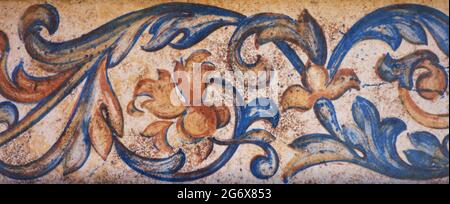 detail of a border painted on a tile with red, orange and blue flowers Stock Photo