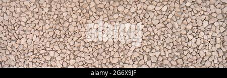 Panoramic close-up of exposed aggregate concrete made of small angular stones Stock Photo