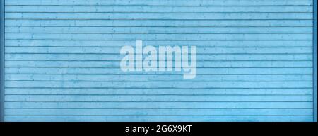 Detail of a wide, old, light blue garage door made of horizontal boards Stock Photo