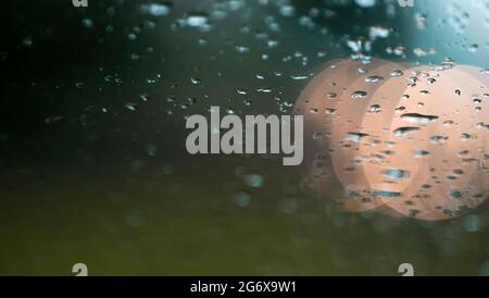 Raindrops on the windshield and car lights The scenery is charming and romantic Ahmed Arnaoty Stock Photo