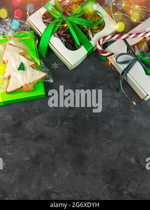Christmas Gift boxes with set of different dried fruits nuts candied citrus individually wrapped flat lay vertical copy space. Winter holidays celebra Stock Photo