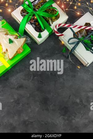 Christmas Gift boxes with set of different dried fruits nuts candied citrus individually wrapped flat lay vertical copy space. Winter holidays celebra Stock Photo