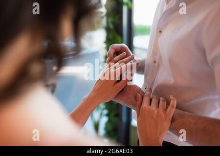 cropped view of man wearing engagement ring on finger of woman Stock Photo