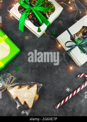 Christmas Gift boxes with set of different dried fruits nuts candied citrus individually wrapped flat lay vertical copy space. Winter holidays celebra Stock Photo
