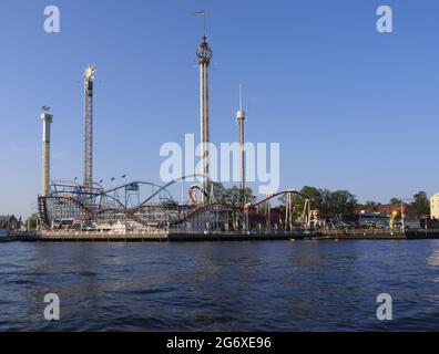 Seafront fairground in Helsinki Sweden with fairground rides overlooking the sea Stock Photo