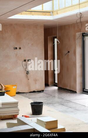 The interior of an ongoing renovation of an extension with a roof light and materials on the floor Stock Photo