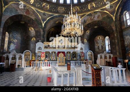 The gold gilt altar of the church of Saints Anthony and Theodosius is lighted by an elaborate candelabra and sunshine streaming through  domed roof. Stock Photo