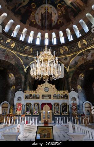 The gold gilt altar of the church of Saints Anthony and Theodosius is lighted by an elaborate candelabra and sunshine streaming through  domed roof. Stock Photo