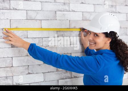 female builder using tape measure Stock Photo