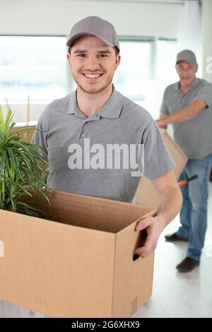 two delivery men carrying cardboard boxes Stock Photo