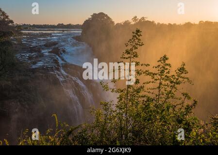 The rays of the rising sun catching the Devil’s Cataract at Victoria Falls in winter, from viewing point 3 on the Zimbabwean side. Stock Photo