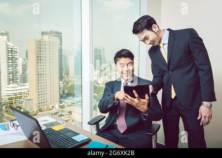 Two smiling businessmen looking at digital tablet Stock Photo