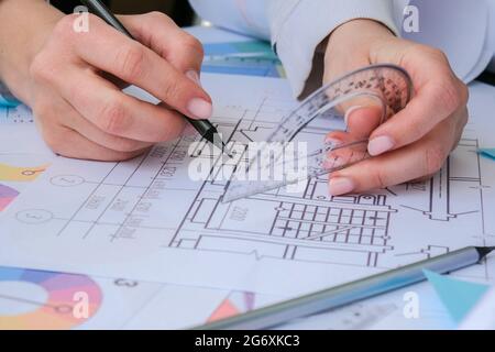Hands use pencil with a protractor. Architectural Project drawings with tools. Architects workplace. Engineering Interior designer's working table Stock Photo