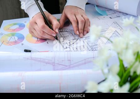 Hands use pencil with a protractor. Architectural Project drawings with tools. Architects workplace. Engineering Interior designer's working table Stock Photo