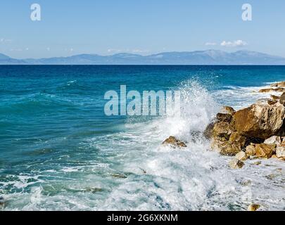 Corinthia. Corinthian Gulf. Stones, waves, splashes on a sunny day. Stock Photo