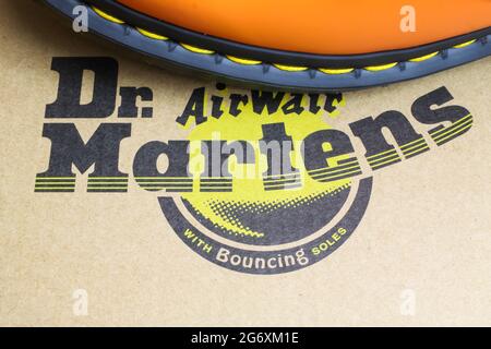 Viersen, Germany - July 1. 2021: Closeup of isolated cardboard shoe box with dr martens label lettering and part of orange color boot with black sole Stock Photo