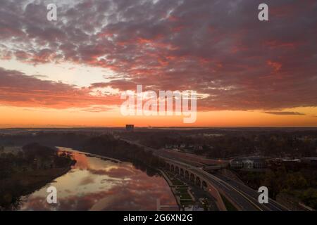 Aerial of a city along the water in early morning with reflections from the colorful sky. Stock Photo