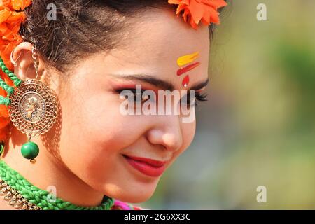 KOLKATA , INDIA - MARCH 12, 2017: Beautiful young girl with spring festive make up with flowers , joyful expression at Holi/Spring festival,known as D Stock Photo