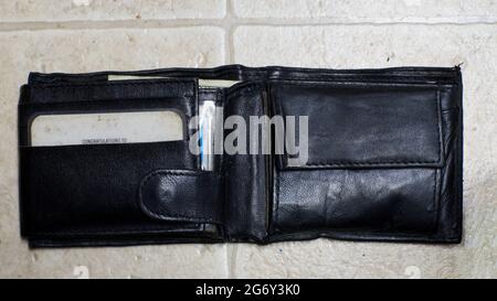 An Opened Wallet With Cash Peeking Out Slightly Stock Photo