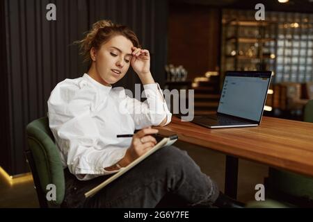 Beautiful woman working on laptop at cafe Stock Photo