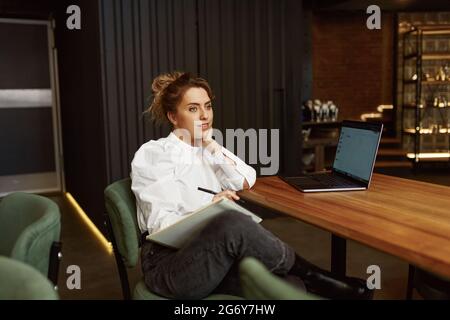 Woman using laptop while working at modern cafe Stock Photo