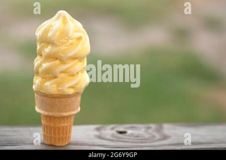 Vanilla Soft Serve Ice Cream Cone Melting in the Summer Heat Stock Photo
