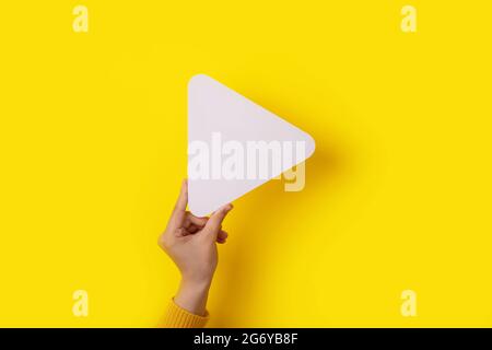 play symbol in hand over yellow background, multimedia concept Stock Photo