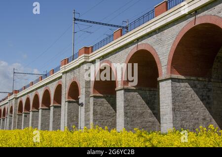 Beautiful scene of viaduct type of bridge surrounded by green fields Stock Photo