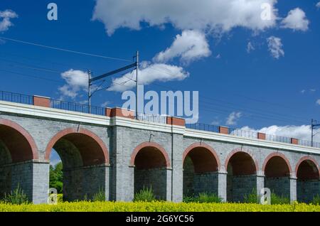 Beautiful scene of viaduct type of bridge surrounded by green fields Stock Photo