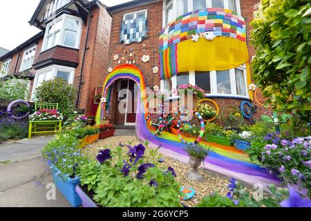 Leicester, Leicestershire, UK 9th July 2021. UK News. Mixed-media artist Alison Carpenter-Hughes with her art installation ‘Blooming Lovely,’  on the front of her house in Aylestone, Leicester. Mixing textiles and flowers to bring an element of colour and nature into the city the art work has been commission by Vehicle Arts for the ‘Up Your Street’ project. As there has been such a lack of access to the arts over this last year, the premise of the project is to brighten up the streets in the local area and to get people engaged. Credit: Alex Hannam/Alamy Live News Stock Photo