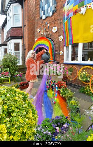 Leicester, Leicestershire, UK 9th July 2021. UK News. Mixed-media artist Alison Carpenter-Hughes with her art installation ‘Blooming Lovely,’  on the front of her house in Aylestone, Leicester. Mixing textiles and flowers to bring an element of colour and nature into the city the art work has been commission by Vehicle Arts for the ‘Up Your Street’ project. As there has been such a lack of access to the arts over this last year, the premise of the project is to brighten up the streets in the local area and to get people engaged. Credit: Alex Hannam/Alamy Live News Stock Photo