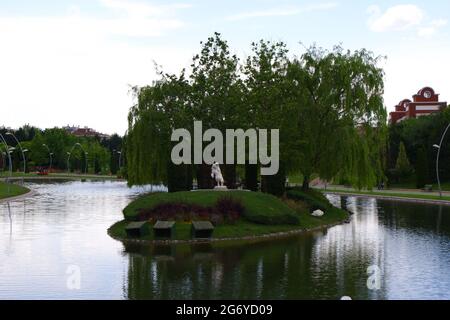 White Sculpture of a woman in protective position on a small island in river Stock Photo