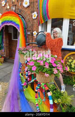 Leicester, Leicestershire, UK 9th July 2021. UK News. Mixed-media artist Alison Carpenter-Hughes with her art installation ‘Blooming Lovely,’  on the front of her house in Aylestone, Leicester. Mixing textiles and flowers to bring an element of colour and nature into the city the art work has been commission by Vehicle Arts for the ‘Up Your Street’ project. As there has been such a lack of access to the arts over this last year, the premise of the project is to brighten up the streets in the local area and to get people engaged. Credit: Alex Hannam/Alamy Live News Stock Photo