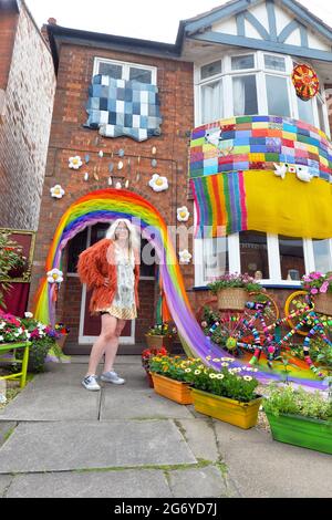 Leicester, Leicestershire, UK 9th July 2021. UK News. Mixed-media artist Alison Carpenter-Hughes with her art installation ‘Blooming Lovely,’  on the front of her house in Aylestone, Leicester. Mixing textiles and flowers to bring an element of colour and nature into the city the art work has been commission by Vehicle Arts for the ‘Up Your Street’ project. As there has been such a lack of access to the arts over this last year, the premise of the project is to brighten up the streets in the local area and to get people engaged. Credit: Alex Hannam/Alamy Live News Stock Photo