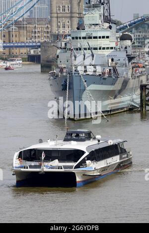 London, England, UK. Uber Boat / Thames Clipper, near HMS Belfast, Tower Bridge in the background Stock Photo