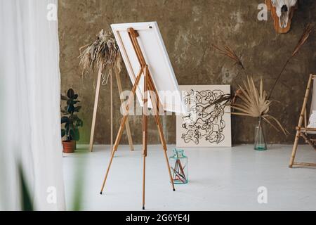 Bright art studio with easel and brushes Stock Photo